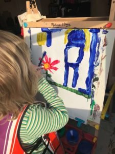 Child painting on art easel while mom is sick.