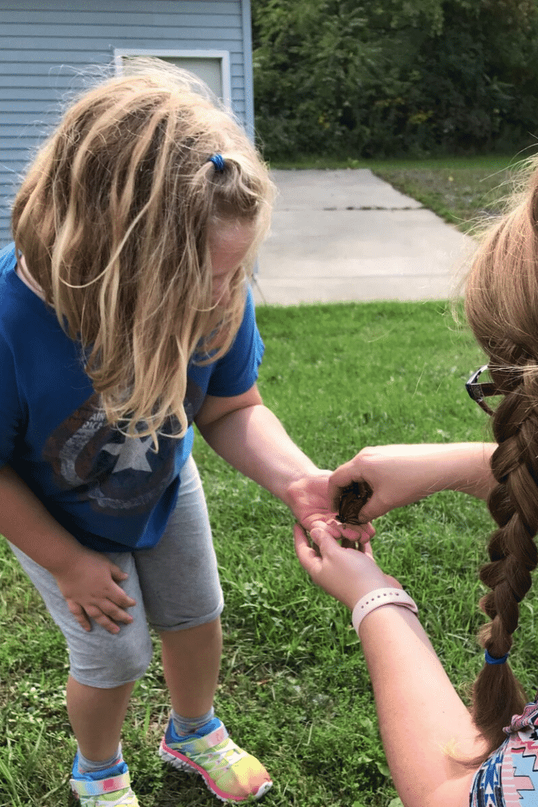 Mom giving Monarch butterfly to daughter to release